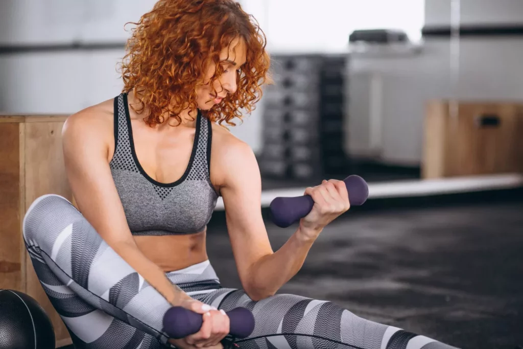 Woman with dumbbells at the gym