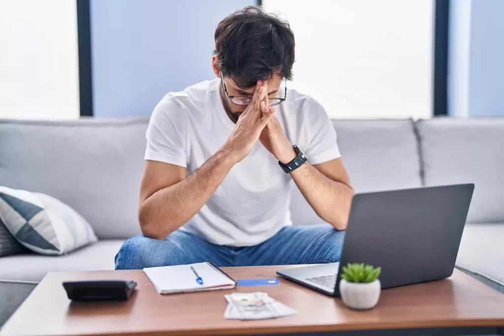 Young man stressed using laptop