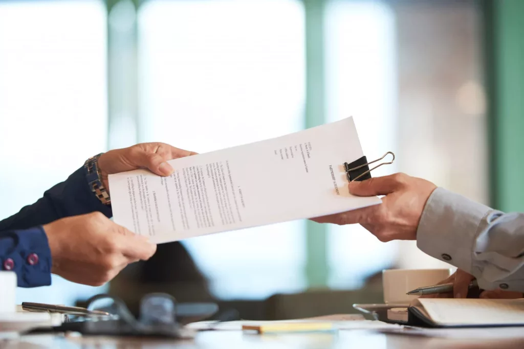 Hands passing the document