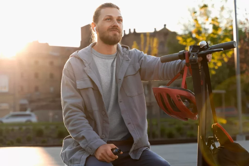 Man sitting next to his scooter