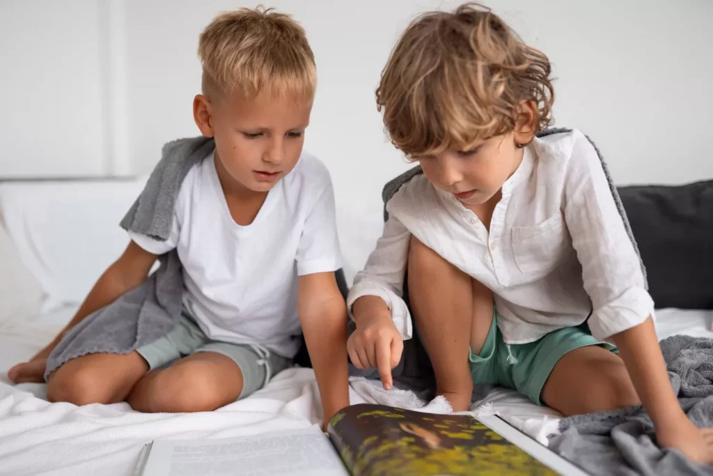 Two kids sitting on the bed