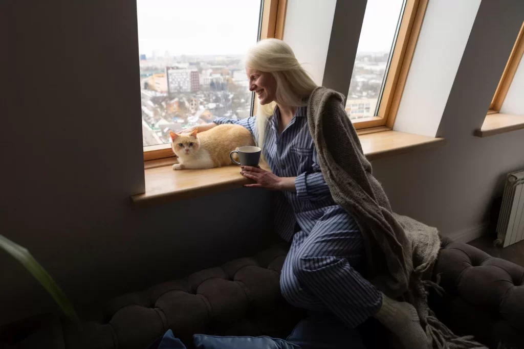 Woman looking at a cat and smiling